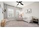 Bright, carpeted bedroom with modern crib, stylish glider, and dual windows for natural light at 15230 Ravenall Dr, Huntersville, NC 28078