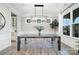Bright dining room boasts modern light fixture, hardwood floors, and clear acrylic chairs at 15230 Ravenall Dr, Huntersville, NC 28078