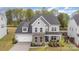 Charming two-story home with stone accents, a well-manicured lawn, and a welcoming front porch for relaxation at 15230 Ravenall Dr, Huntersville, NC 28078