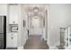 Bright hallway with white trim, hardwood floors and stylish lighting creates a welcoming path to the home's interior at 15230 Ravenall Dr, Huntersville, NC 28078