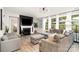 Bright living room features a fireplace, hardwood floors, and a comfortable gray sectional sofa and matching chairs at 15230 Ravenall Dr, Huntersville, NC 28078