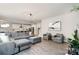 Open-concept living space with gray sectional, hardwood floors, and white kitchen in the background for easy entertaining at 15230 Ravenall Dr, Huntersville, NC 28078