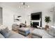 Bright living room features a fireplace, hardwood floors, and a comfortable gray sectional sofa and matching chairs at 15230 Ravenall Dr, Huntersville, NC 28078
