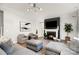 Bright living room features a fireplace, hardwood floors, and a comfortable gray sectional sofa and matching chairs at 15230 Ravenall Dr, Huntersville, NC 28078
