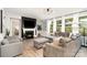 Bright living room features a fireplace, hardwood floors, and a comfortable gray sectional sofa and matching chairs at 15230 Ravenall Dr, Huntersville, NC 28078