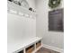 Organized mudroom with a built-in bench, storage cubbies, hooks and Gathering calendar at 15230 Ravenall Dr, Huntersville, NC 28078