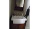Small bathroom featuring a pedestal sink with dark wood cabinets and a decorative mirror at 154 Tiger Oak Ln, Rockwell, NC 28138