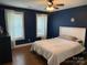 Charming bedroom with dark blue walls, hardwood floors, and two bright windows at 154 Tiger Oak Ln, Rockwell, NC 28138