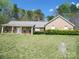 Charming brick home featuring a welcoming front porch with rocking chairs and a well-maintained lawn at 154 Tiger Oak Ln, Rockwell, NC 28138