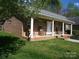 Inviting brick front porch with classic white columns and comfortable rocking chairs at 154 Tiger Oak Ln, Rockwell, NC 28138