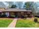 Charming single story home with brown siding, stone accents, manicured lawn and walkway to the front door at 1713 12Th Ne St, Hickory, NC 28601