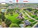 Aerial view of homes with pools, green lawns, and mature trees in the neighborhood with shopping close by at 1902 Windmere Dr, Monroe, NC 28110