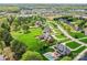 Aerial view of homes with pools, green lawns, and mature trees in the neighborhood with shopping close by at 1902 Windmere Dr, Monroe, NC 28110
