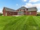Backyard view showcasing patio, expansive lawns, and brick facade at 1902 Windmere Dr, Monroe, NC 28110