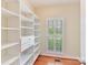 Bright walk-in closet features built-in shelving, drawers, and natural light from a window at 1902 Windmere Dr, Monroe, NC 28110
