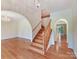 Inviting entryway with hardwood floors, elegant staircase, and arched doorways at 1902 Windmere Dr, Monroe, NC 28110