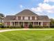 Charming two-story brick home with grand entrance, symmetrical design, manicured lawn, and a circular driveway at 1902 Windmere Dr, Monroe, NC 28110