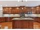 An island kitchen boasts wooden cabinets, stainless appliances, granite countertops, and hardwood floors at 1902 Windmere Dr, Monroe, NC 28110