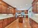An open concept kitchen with wood cabinets, stainless steel appliances, and hardwood floors at 1902 Windmere Dr, Monroe, NC 28110