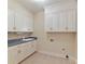 Laundry room features white cabinets, tile flooring, and a utility sink at 1902 Windmere Dr, Monroe, NC 28110