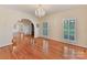 Open-concept living room featuring hardwood floors, arched doorways, and a crystal chandelier at 1902 Windmere Dr, Monroe, NC 28110