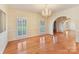 Spacious living room featuring hardwood floors, natural light, and elegant chandelier at 1902 Windmere Dr, Monroe, NC 28110