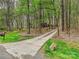 Long concrete driveway leads to a house through a wooded area with grassy areas on either side at 2313 Beechwood Dr, Waxhaw, NC 28173