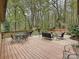 Spacious deck with an outdoor dining area, seating, and a serene view of the wooded landscape at 2313 Beechwood Dr, Waxhaw, NC 28173