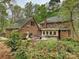 Brick home featuring a patio with outdoor seating and dining areas surrounded by lush greenery at 2313 Beechwood Dr, Waxhaw, NC 28173