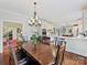 Open-concept dining room showcasing hardwood floors, a chandelier, and seamless transition to kitchen at 2313 Beechwood Dr, Waxhaw, NC 28173