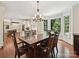 Open-concept dining area with a view of the modern kitchen and a large bay window overlooking the outdoor landscape at 2313 Beechwood Dr, Waxhaw, NC 28173