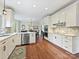 Modern kitchen features white cabinets, stainless appliances and hardwood floors at 2313 Beechwood Dr, Waxhaw, NC 28173