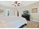 Spacious main bedroom featuring a ceiling fan, neutral color walls, carpet, and a large flat-screen TV at 2313 Beechwood Dr, Waxhaw, NC 28173