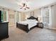 Spacious main bedroom featuring a ceiling fan, neutral color walls, carpet, and windows with sheer curtains at 2313 Beechwood Dr, Waxhaw, NC 28173