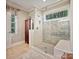 Tiled frameless glass shower featuring a built-in seat and a window to the outdoors at 2313 Beechwood Dr, Waxhaw, NC 28173