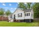 Beautiful home with a white exterior, dark shutters, green lawn and colorful landscaped flower beds at 2414 Remount Rd, Charlotte, NC 28208