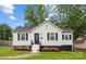 Charming home with a white exterior, black shutters, well manicured lawn and beautifully landscaped flower beds at 2414 Remount Rd, Charlotte, NC 28208