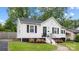 Cozy home with a white exterior, black shutters and landscaped flower beds around the front of the home at 2414 Remount Rd, Charlotte, NC 28208