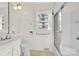 Well-lit bathroom featuring a shower-tub combo, white fixtures, and a window at 252 Stamey Farm Rd, Statesville, NC 28677