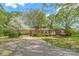 Charming brick home featuring a lush front yard, mature trees, and a convenient carport at 252 Stamey Farm Rd, Statesville, NC 28677