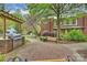 Brick patio with stainless steel grill under pergola, with benches and landscaping at Selwyn Terrace at 2934 Selwyn Ave, Charlotte, NC 28209