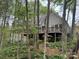 Backyard view through the trees featuring a deck and landscaped area at 3011 Lakewood Edge Dr, Charlotte, NC 28269