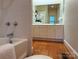 Bathroom with a white tile bath tub and vanity with traditional-style cabinets and wood floor at 3011 Lakewood Edge Dr, Charlotte, NC 28269