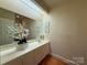 Bathroom features large vanity with a large mirror, white cabinetry, and wood floors at 3011 Lakewood Edge Dr, Charlotte, NC 28269