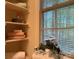 Bathroom featuring built-in open shelving, wood blinds, a plant, and stacked towels at 3011 Lakewood Edge Dr, Charlotte, NC 28269