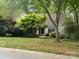 Well-maintained one-story home with a lush green lawn and mature trees at 3011 Lakewood Edge Dr, Charlotte, NC 28269