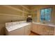 Laundry room features a washer, dryer, laundry sink, counter space, and storage shelving at 3011 Lakewood Edge Dr, Charlotte, NC 28269