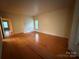 Living room with hardwood floors, window, and open doorway at 3011 Lakewood Edge Dr, Charlotte, NC 28269