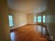 Open living room with hardwood floors and multiple windows for natural light at 3011 Lakewood Edge Dr, Charlotte, NC 28269