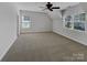 Spacious bedroom with plush carpet, ceiling fan, and two large windows for ample natural light at 3114 Parker Green Trl, Charlotte, NC 28269